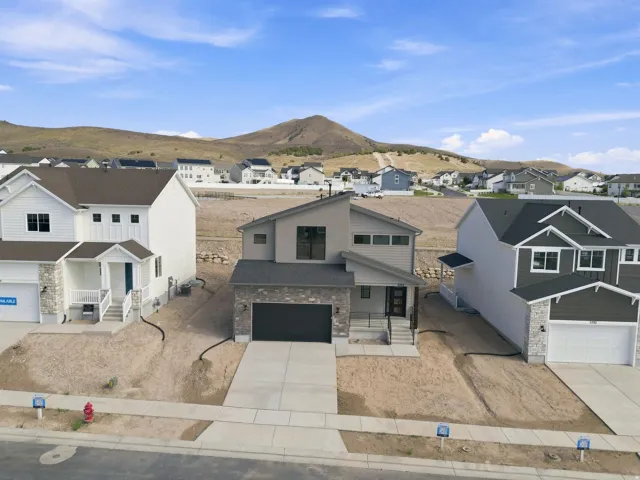 Contemporary exterior featuring a mix of horizontal siding, stone accents, and a dark roof