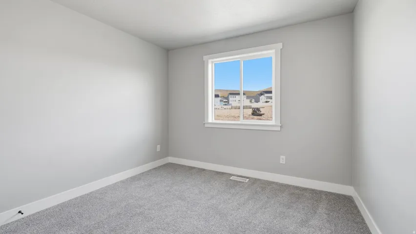 Neutral wall paint, window with white trim, gray carpet flooring, and white ceiling
