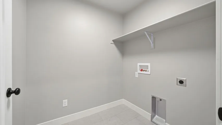 Utility area featuring a built-in shelf, appliance hookups, tile flooring, and a contemporary door handle