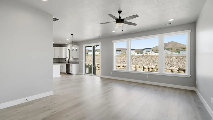 Open concept living space featuring light wood-finish flooring, a ceiling fan with integrated lighting, and recessed lighting