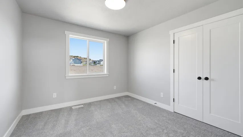 Light gray walls, white trim, and gray carpet