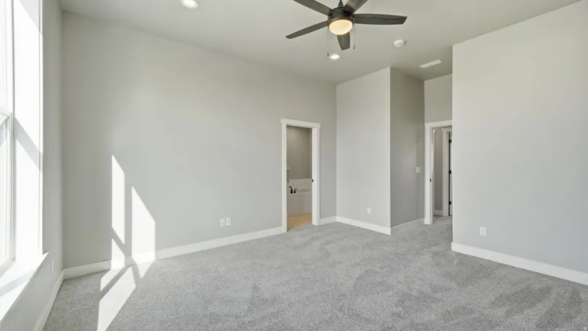 Recessed lighting, ceiling fan with integrated light, light gray wall paint, and gray carpeting