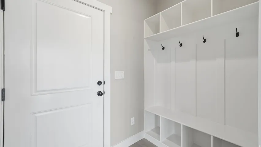 Built-in storage bench with cubbies, overhead shelving, and wall hooks