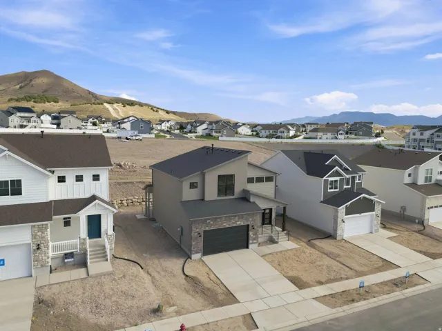 Contemporary exterior design with an attached two-car garage, stone and siding façade, and a paved driveway