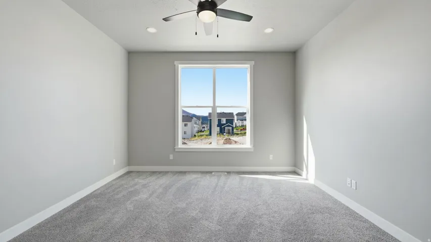 Spacious room featuring carpeted flooring, a large window, recessed lighting, a ceiling fan, and painted walls