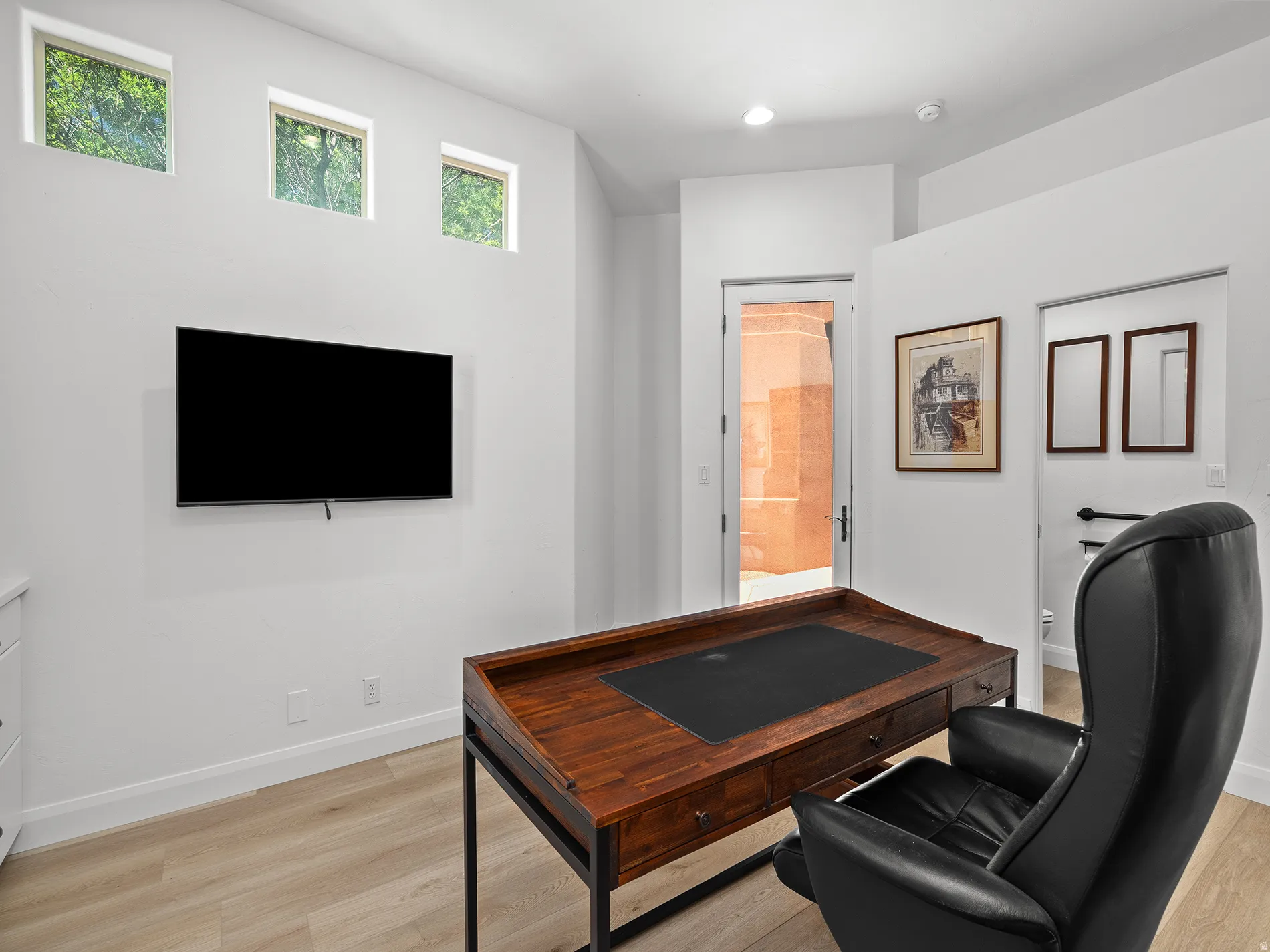 Light wood-finish flooring, white walls, and high transom windows