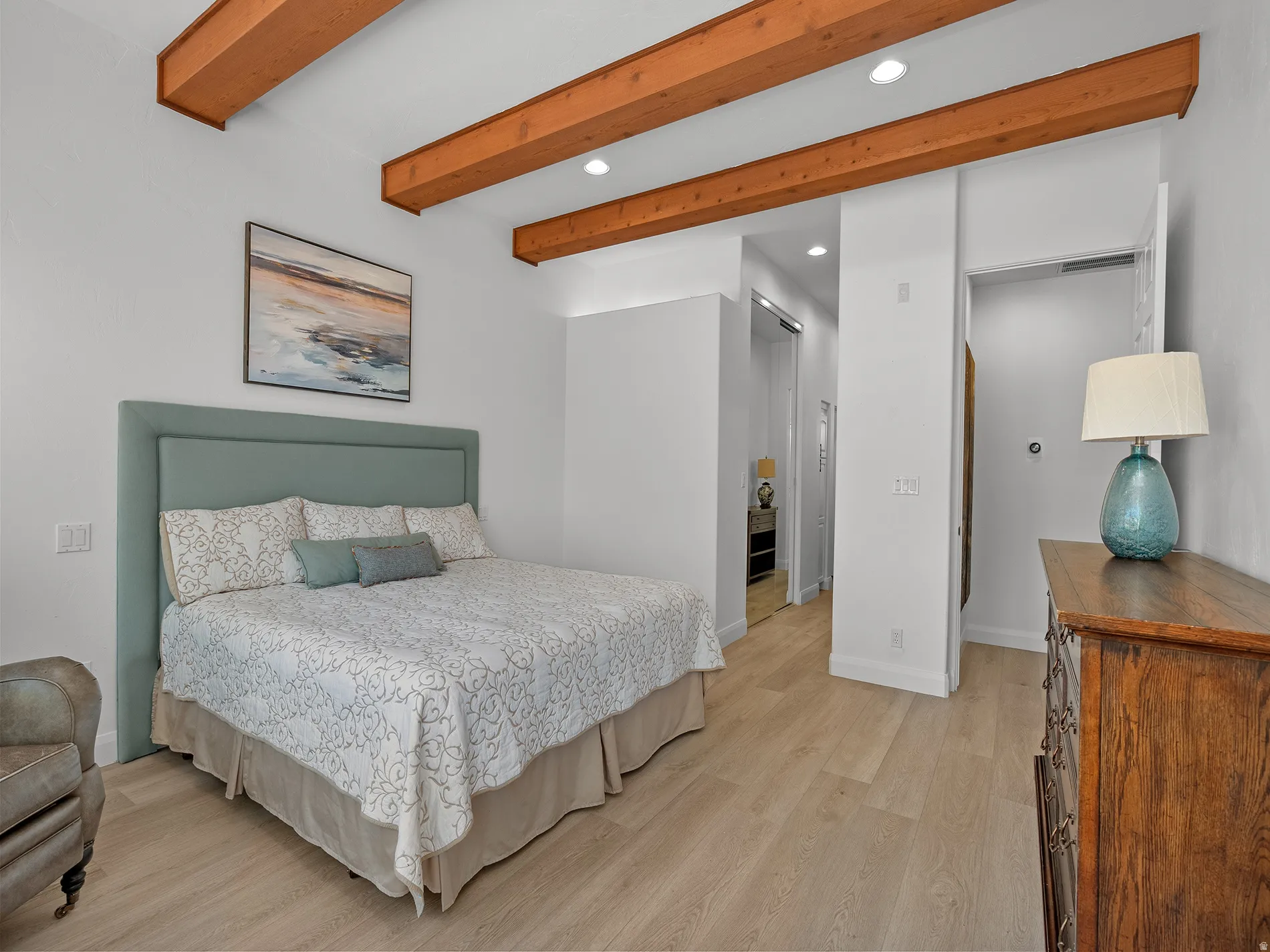 Wood-finish flooring, exposed wood beams, recessed lighting, and white wall finishes