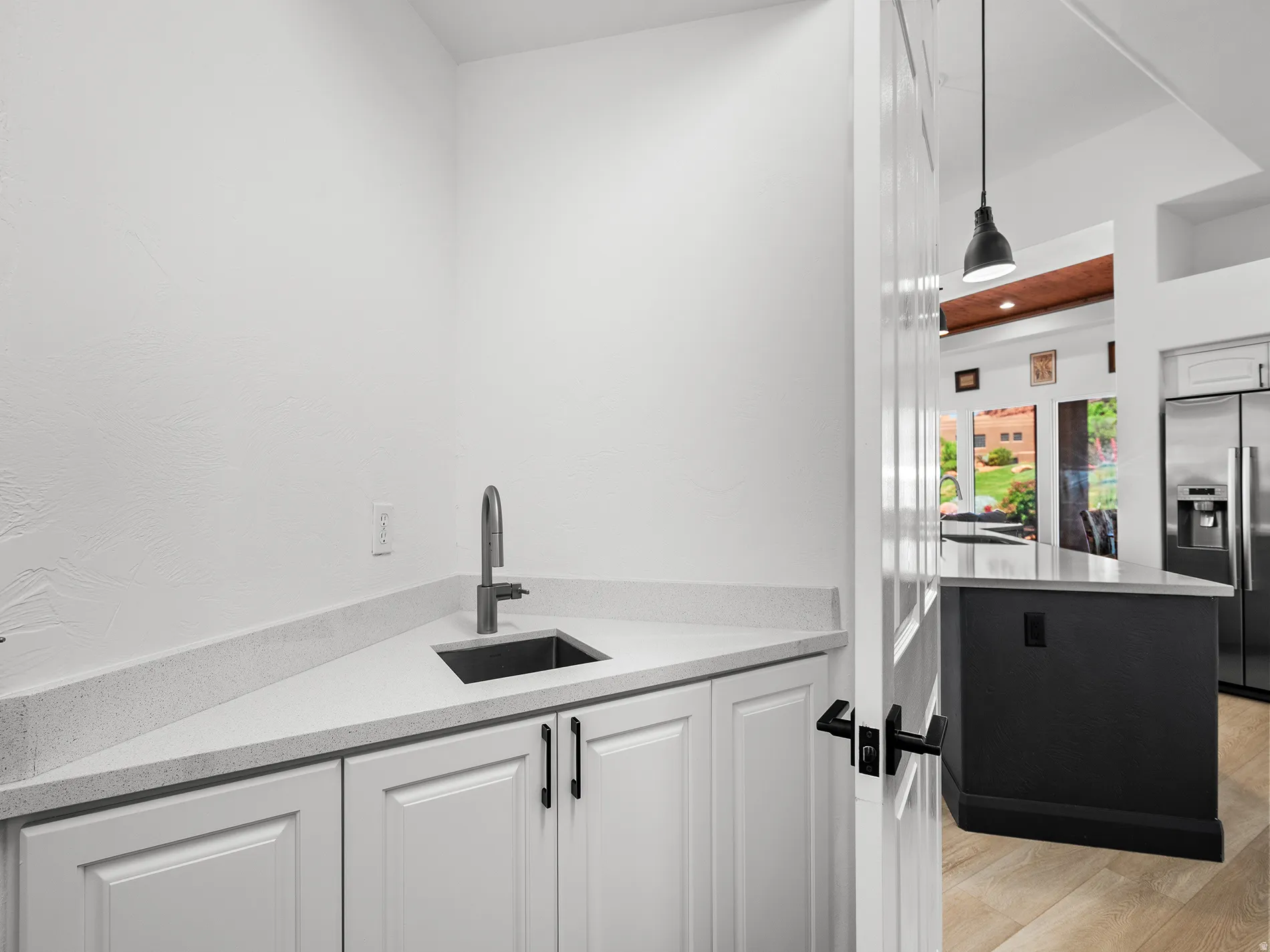 Corner cabinetry with light-toned countertops and a built-in sink