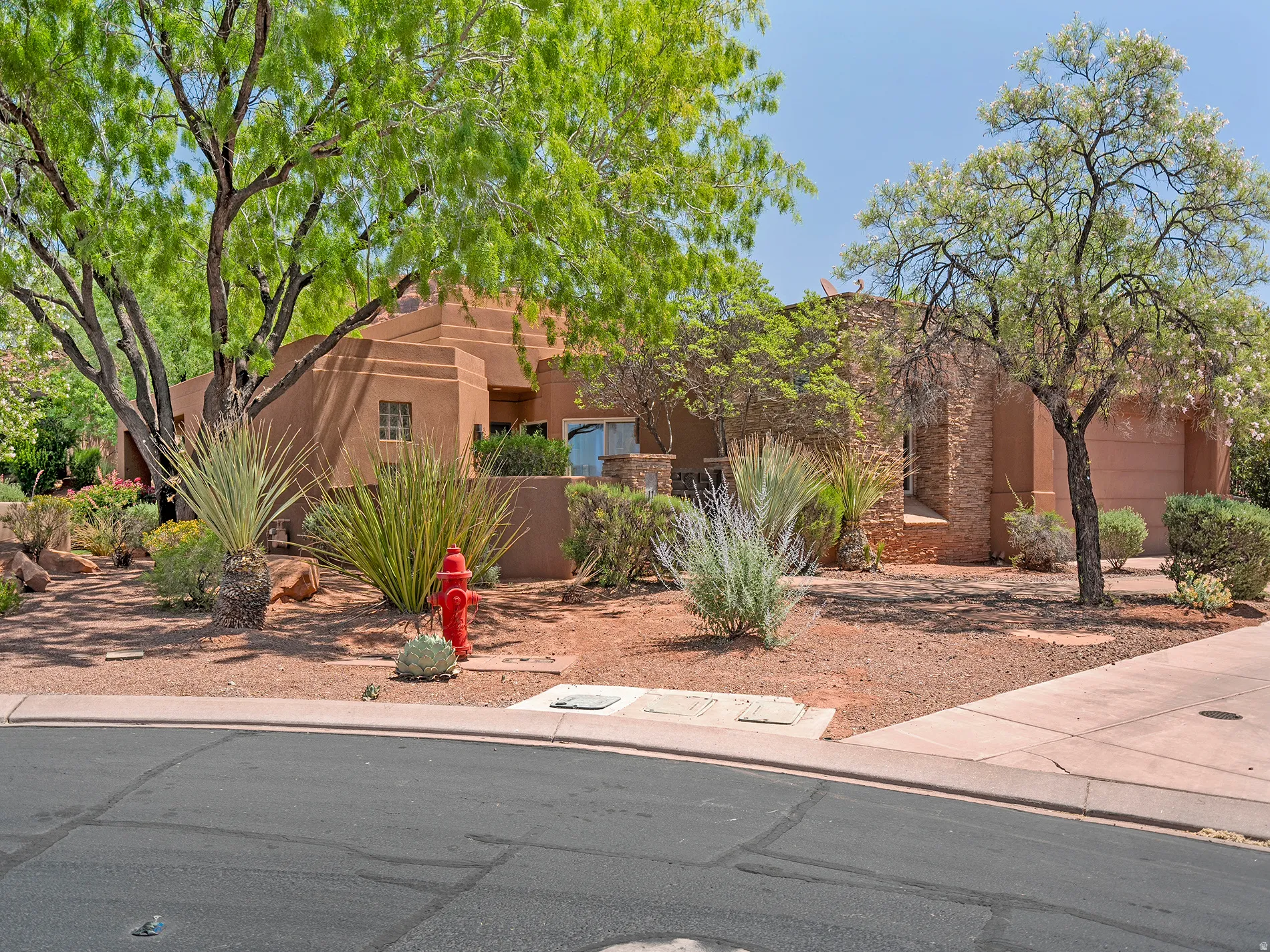 Southwestern architecture with stucco exterior, a stone-clad facade, and desert landscaping