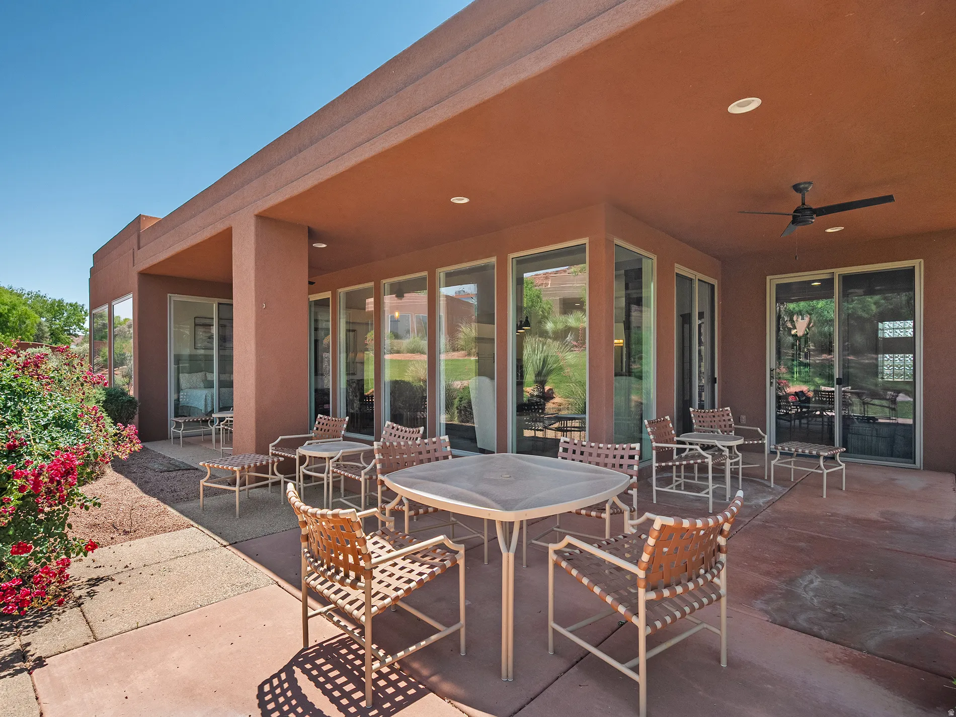 Expansive covered patio featuring a ceiling fan, recessed lighting, and multiple sliding glass doors