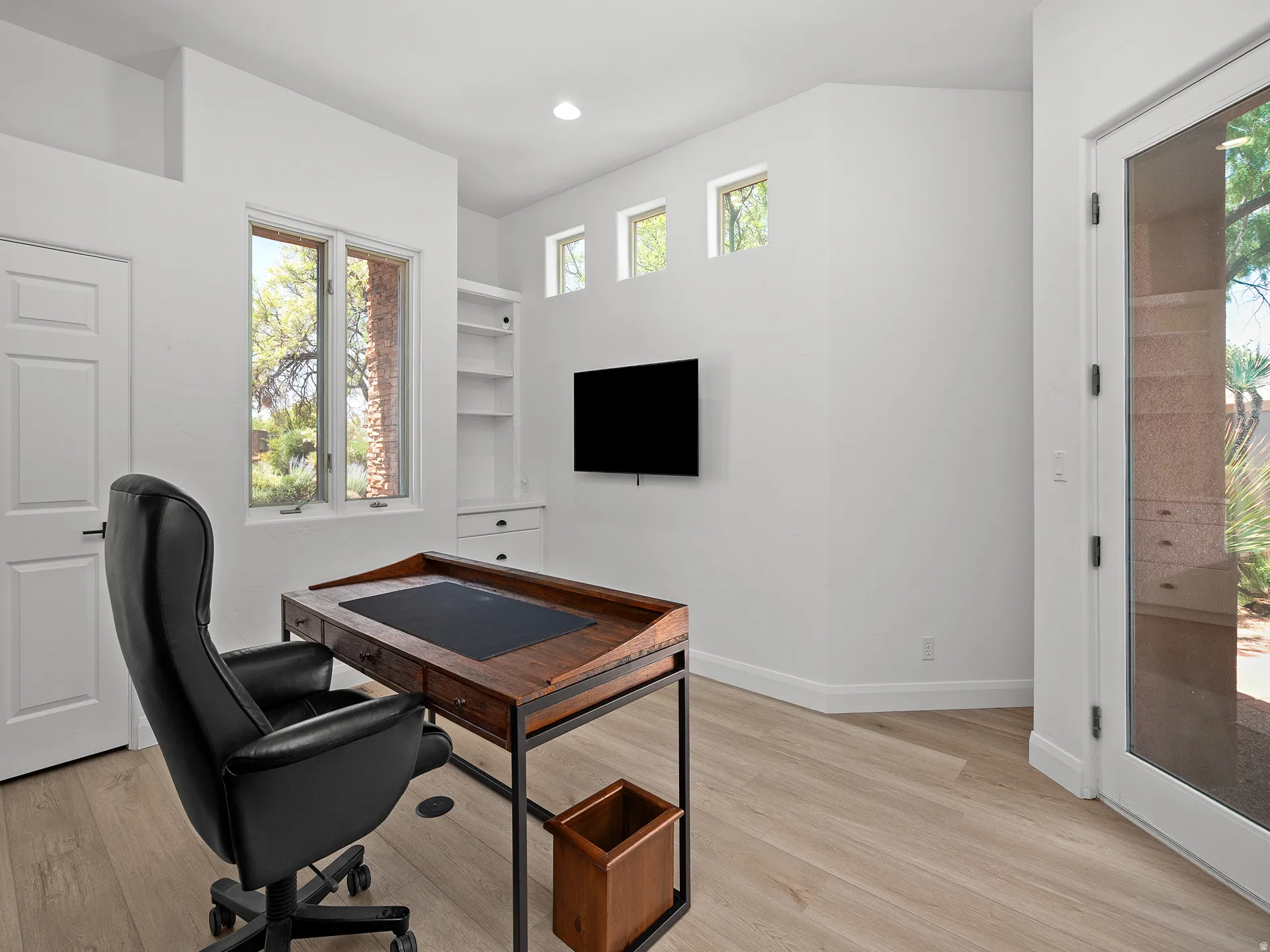 Built-in shelving unit, wood-finish flooring, and multiple windows