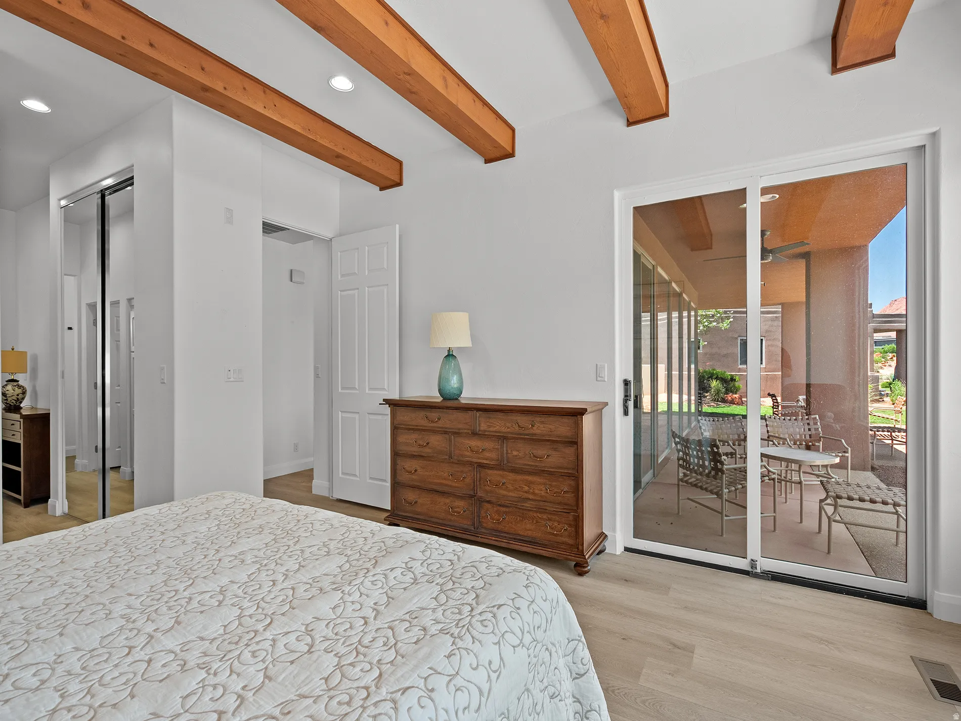 Wood-finish flooring with exposed ceiling beams and recessed lighting