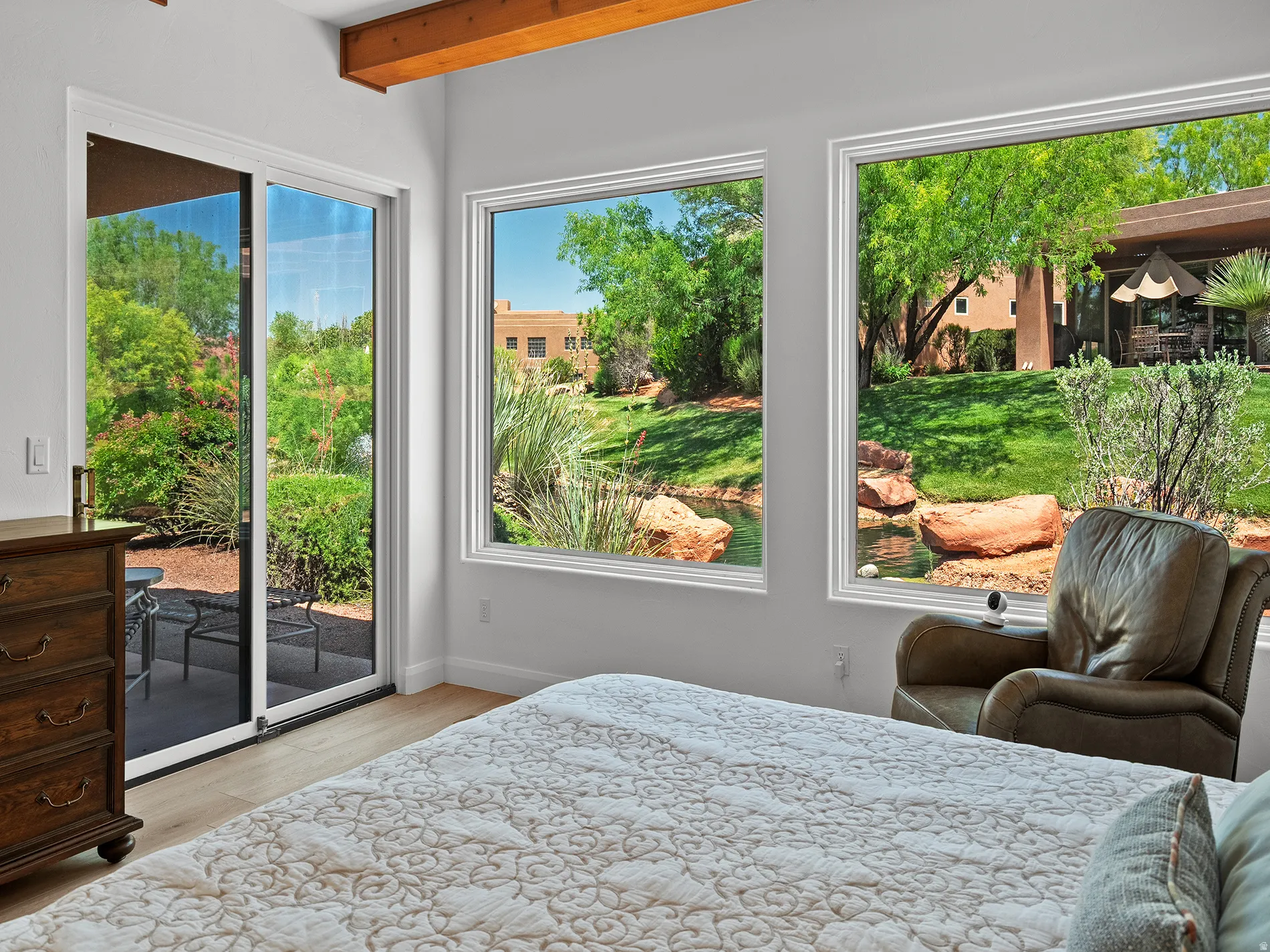 Dual large windows and sliding glass door leading to an outdoor patio