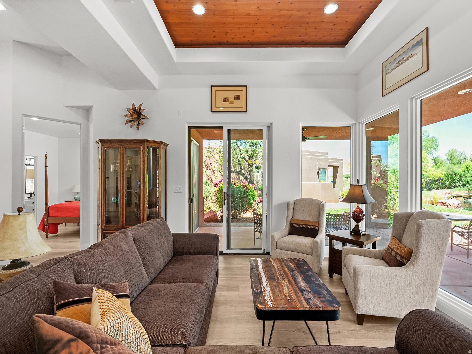 Coffered ceiling with a wood-finish inlay, large sliding glass door, and multiple floor-to-ceiling windows