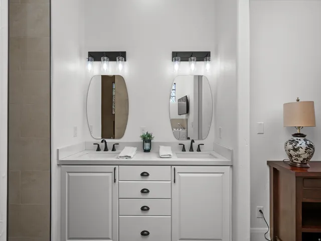 Dual vanity featuring undermount sinks, stone countertops, and matte black fixtures