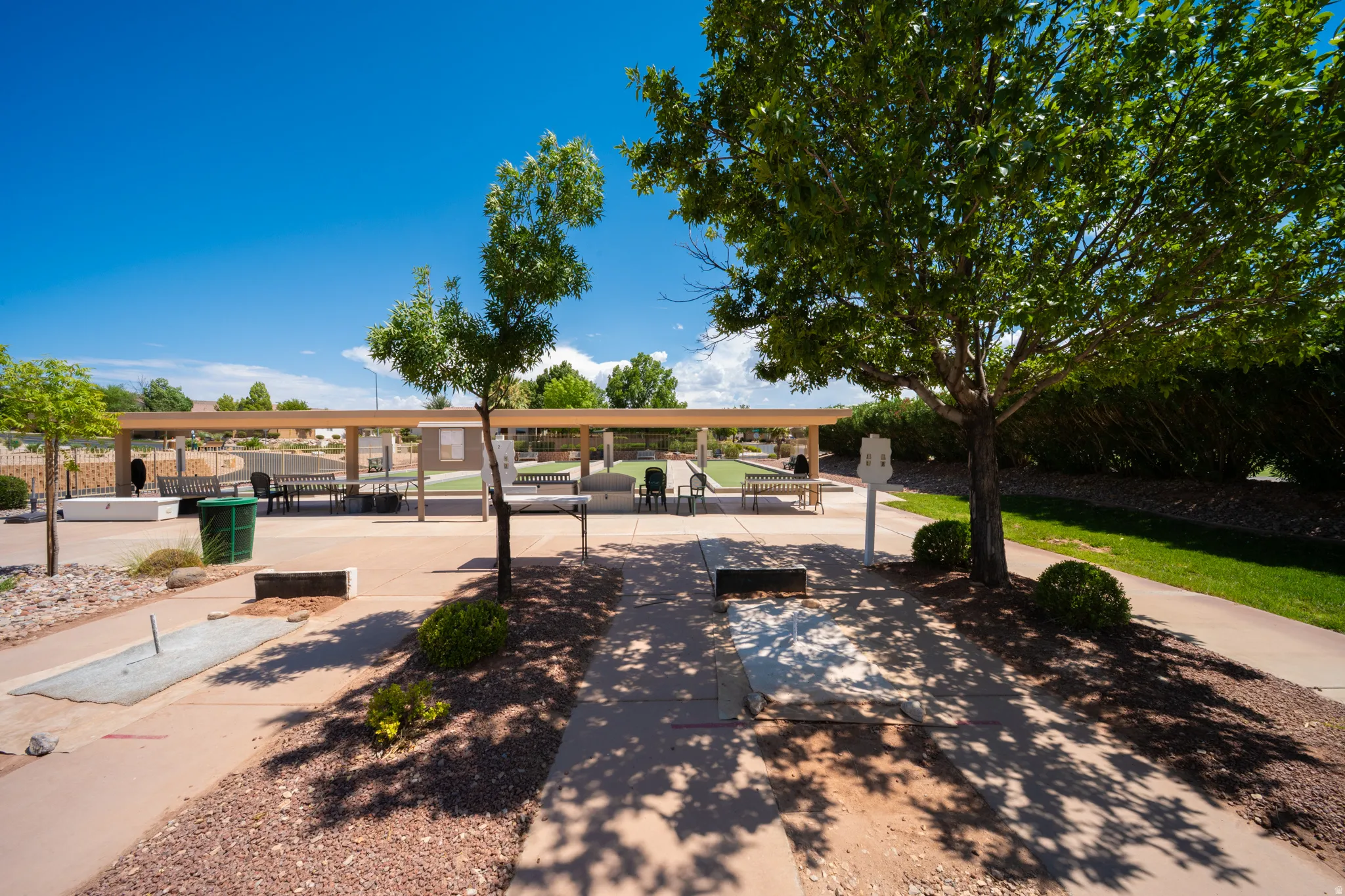 Covered outdoor recreation area with paved pathways and mature trees