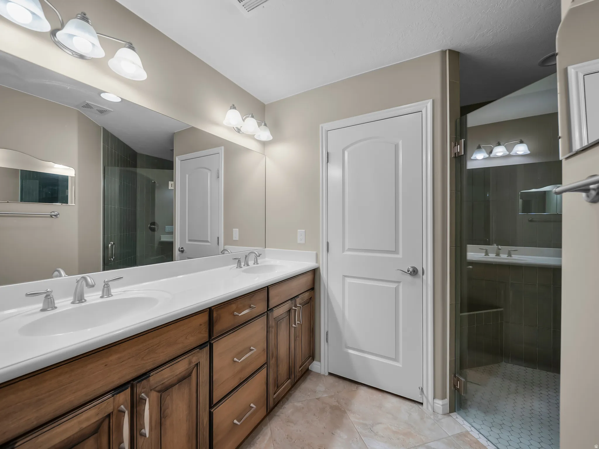 Dual vanity with integrated sinks, wood-finish cabinetry, and brushed nickel fixtures
