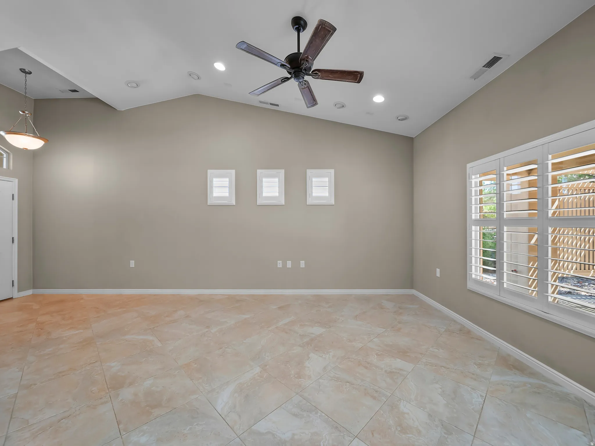 Vaulted ceiling with recessed lighting and a ceiling fan