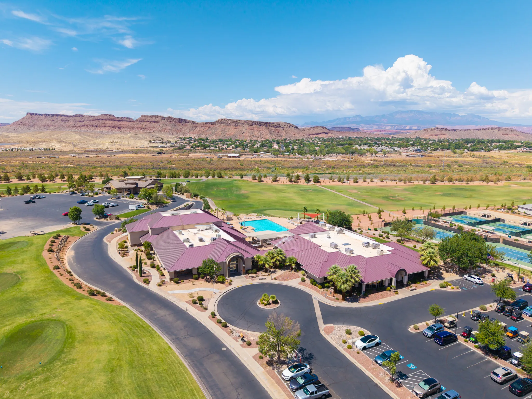 Clubhouse with a swimming pool, tennis courts, and adjacent golf course