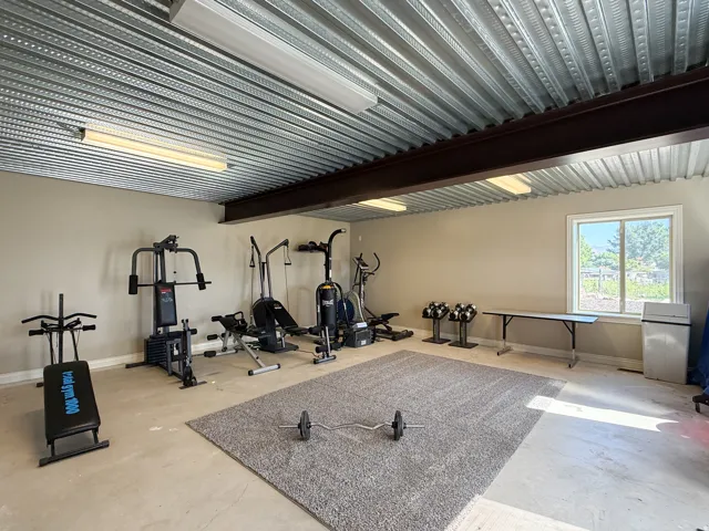 Exposed corrugated metal ceiling with integrated strip lighting and a prominent I-beam