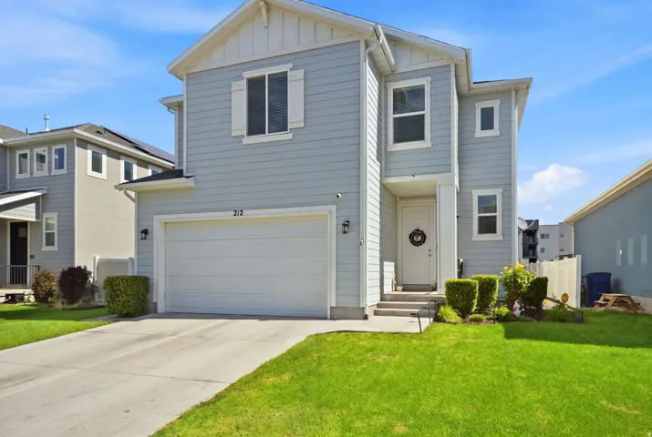 Two-story exterior with light blue siding, a white garage door, and a concrete driveway