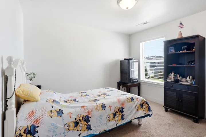 Carpeted flooring, white painted walls, and a single window with blinds