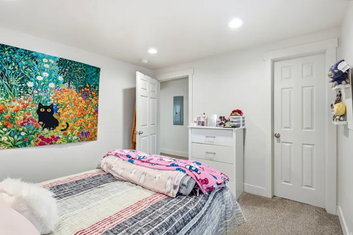 Recessed lighting fixtures illuminate the space, featuring white walls, white trim, and a paneled door