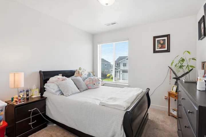 Carpeted flooring, white walls, and a window with horizontal blinds