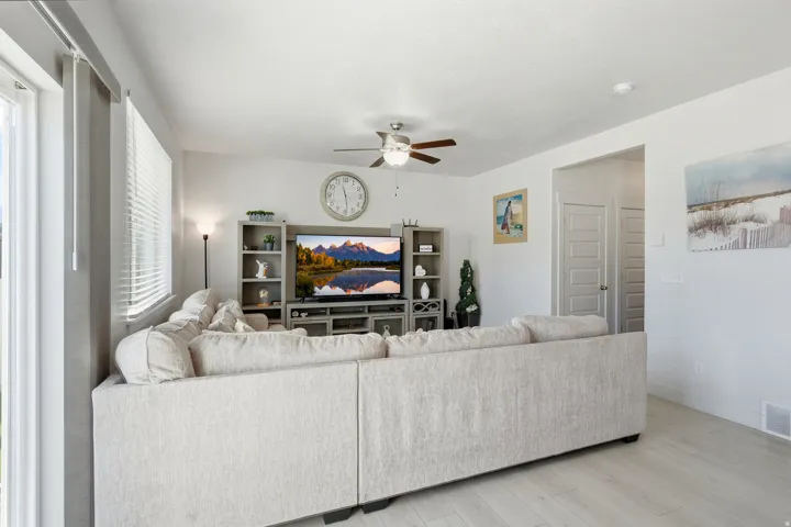 Recessed lighting, wood-finish flooring, ceiling fan with light fixture, and white window blinds