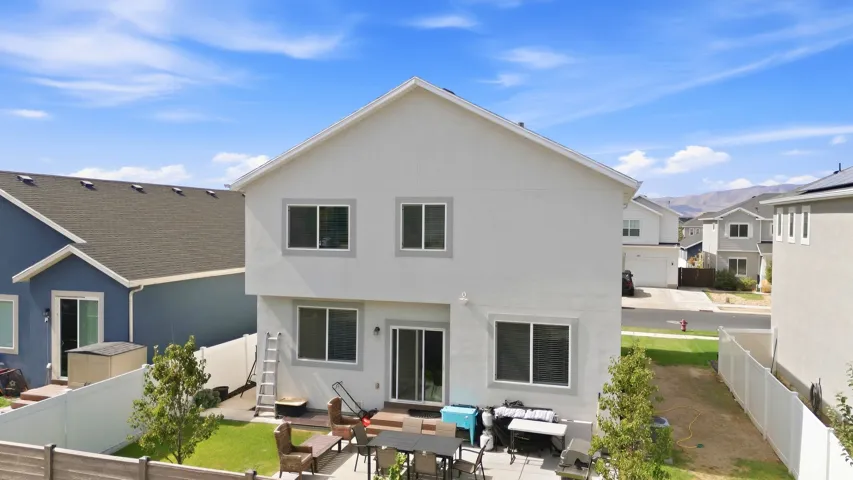 Two-story stucco exterior with multiple windows and a sliding glass door