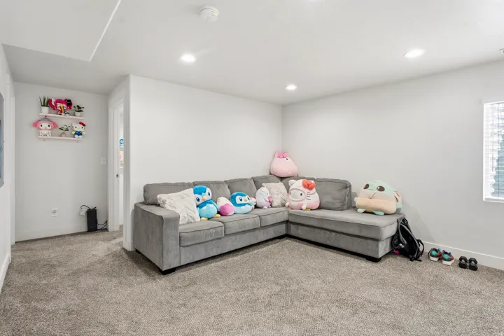 Recessed ceiling lighting, light-toned carpeting, white painted walls, and window with blinds