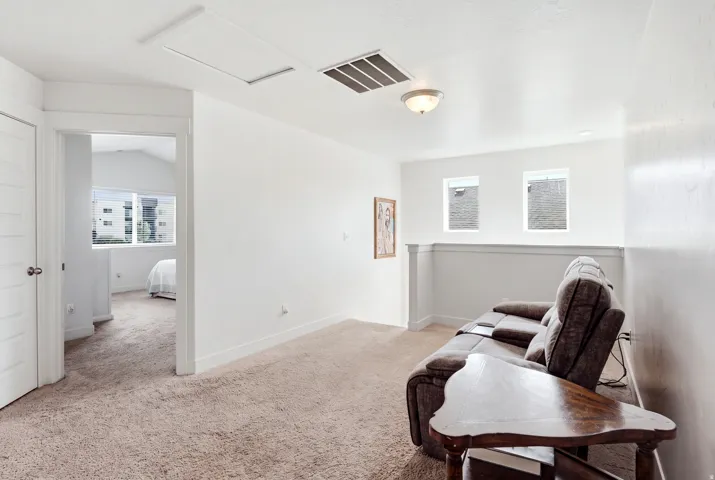Open room with carpeting, two windows, and overhead lighting