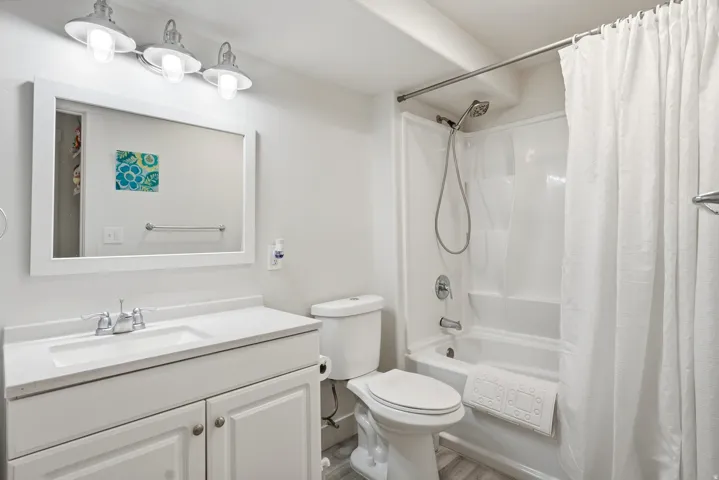 White vanity with integrated sink, chrome faucet, and framed mirror