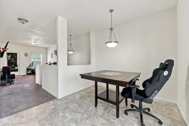 Recessed ceiling lighting, durable tile flooring, a built-in half-wall partition, and a contemporary pendant light fixture