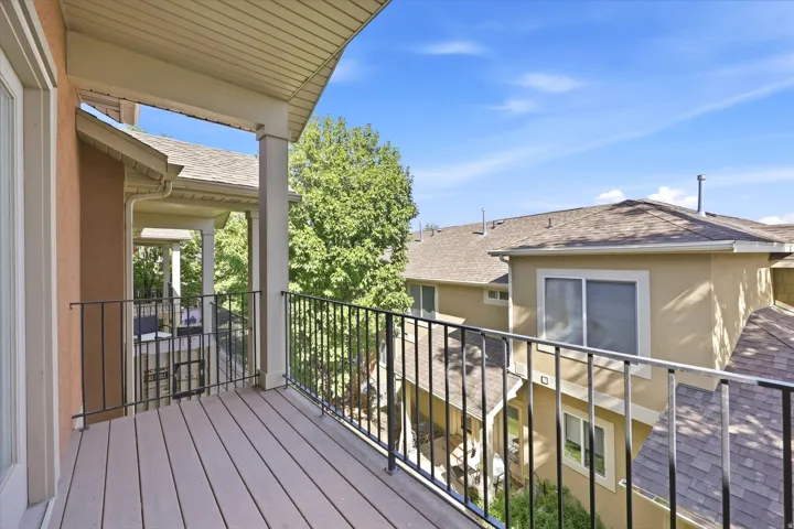 Private balcony with composite decking and black metal railings, offering an exterior living space