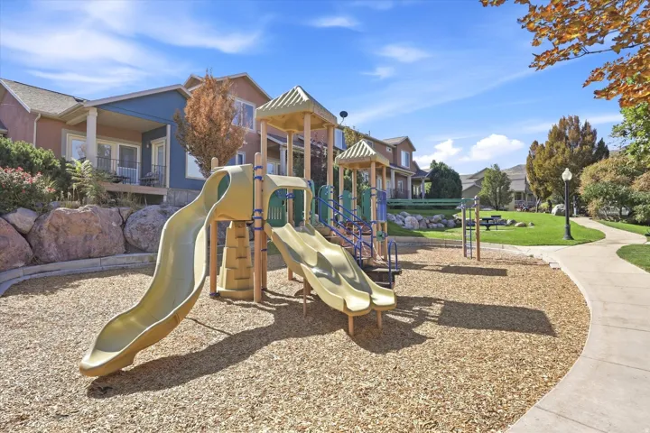 Community playground featuring multiple slides and climbing structures over wood chip surfacing