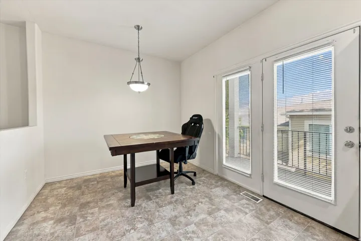 White walls, tiled flooring, pendant light fixture, and French doors with integrated blinds
