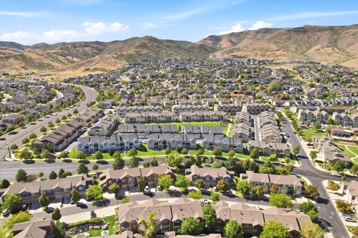 Residential community featuring varied architectural styles and mature landscaping, framed by expansive mountain terrain