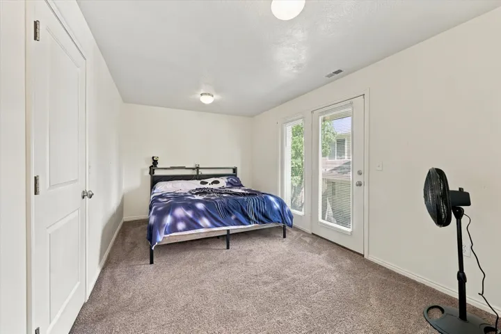 Wall-to-wall carpeting, white interior doors, and a glass-paneled exterior door