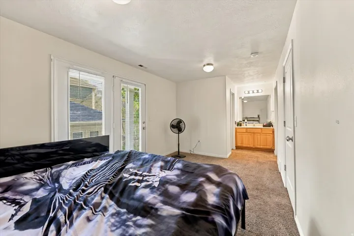Carpeted bedroom featuring white walls and a ceiling-mounted light fixture