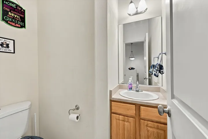 Vanity with an oval undermount sink, wood-finish cabinetry, and a countertop