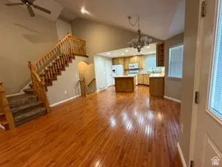 Hardwood flooring throughout the main level, vaulted ceilings, and a built-in staircase