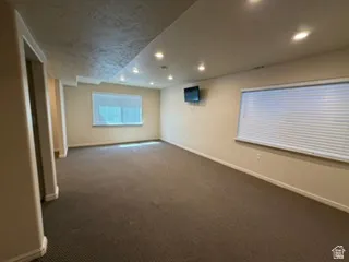 Recessed ceiling lighting, multiple windows with blinds, and neutral wall paint