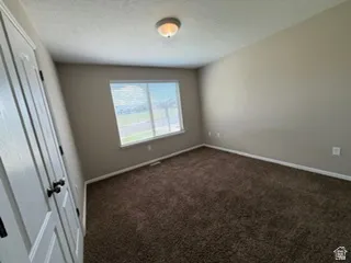 Neutral wall color, wall-to-wall carpeting, and a window with horizontal blinds