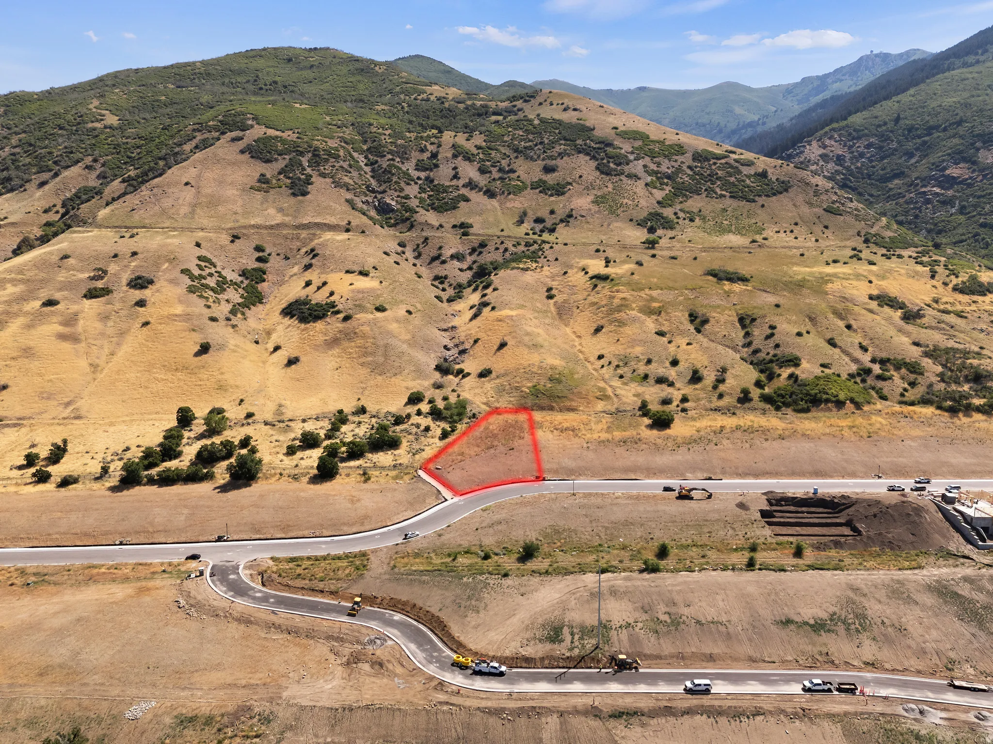 Property parcel with paved road frontage and mountain backdrop