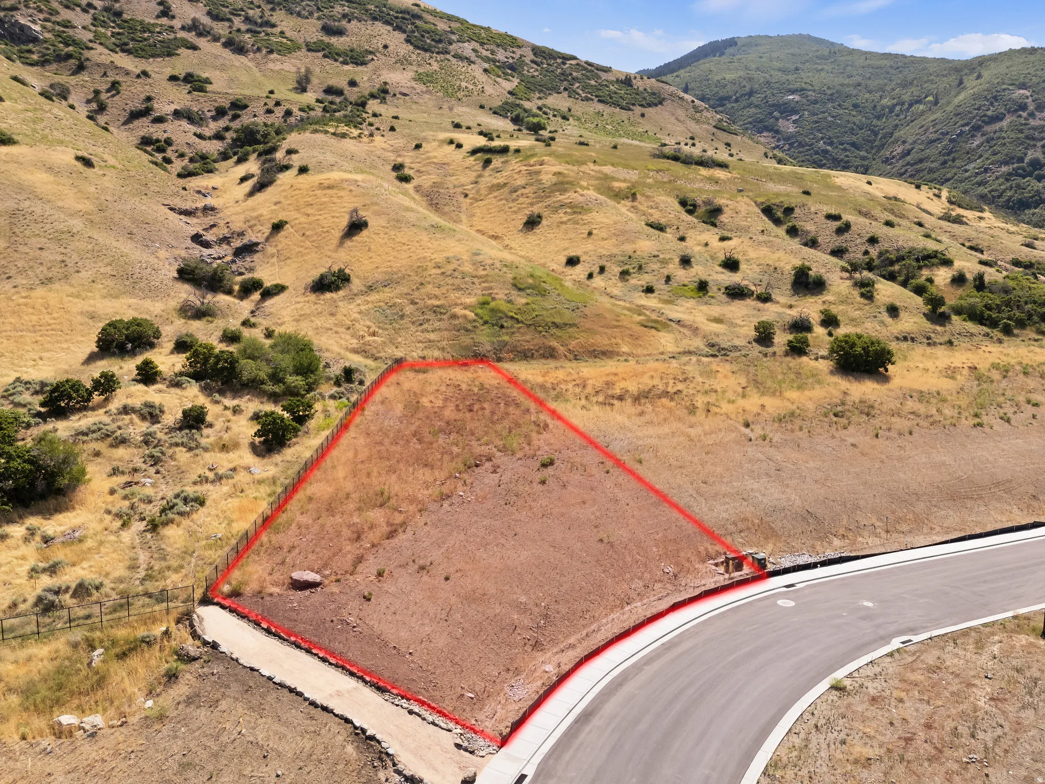 Graded building pad, paved road access, and mountainous terrain