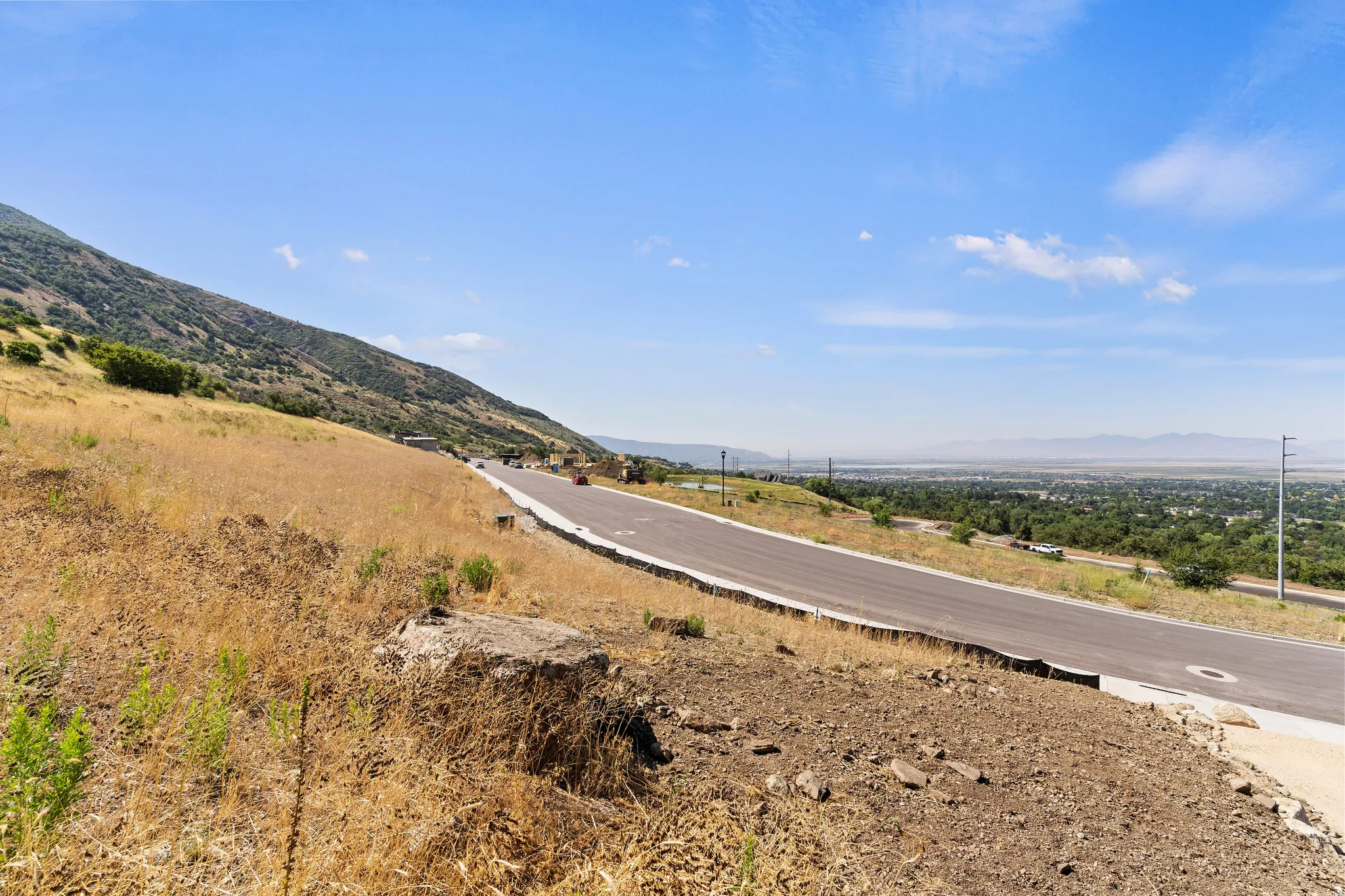 Paved roadway with curbs and a mountainous backdrop