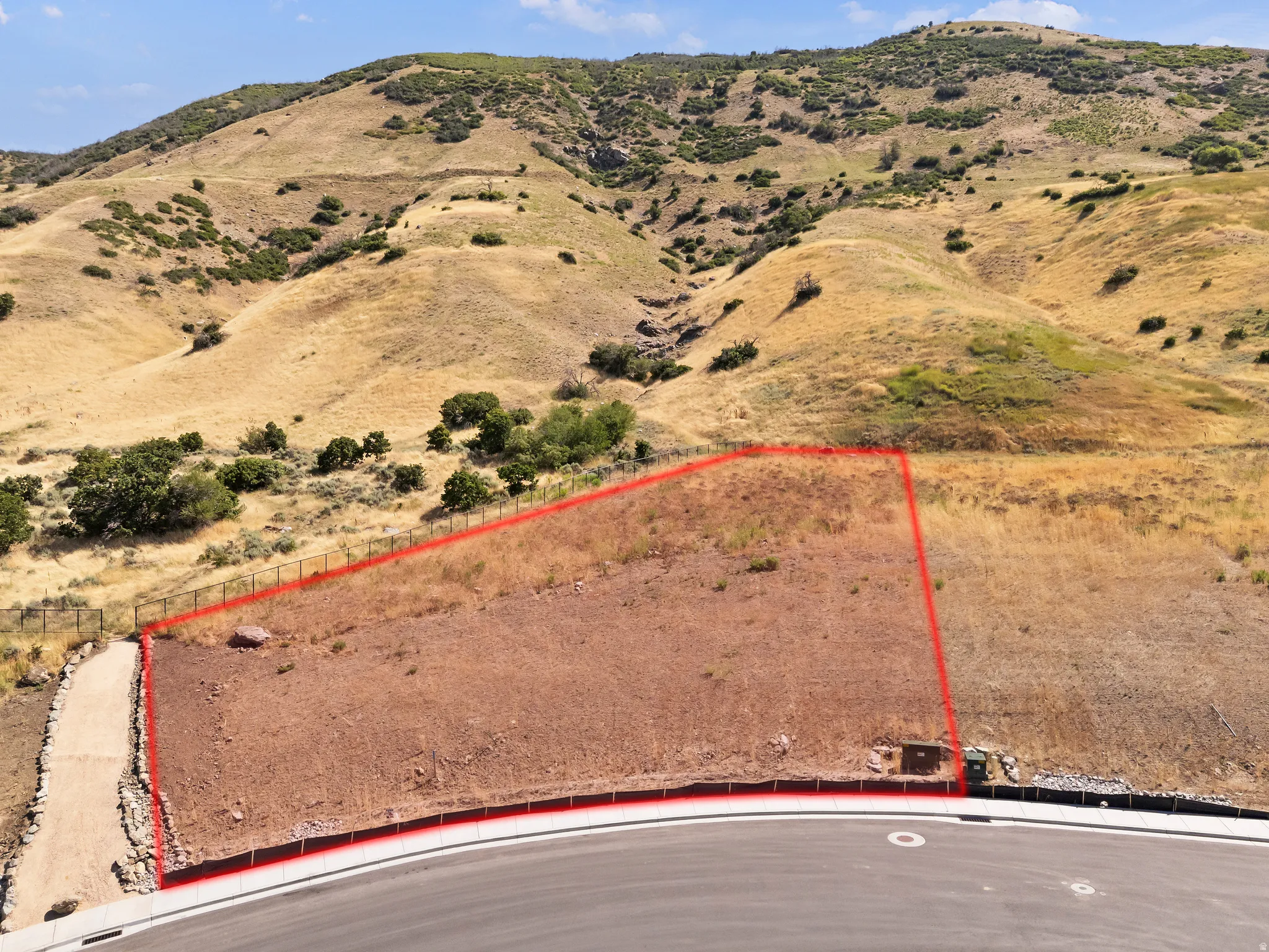 Graded lot with a paved road frontage and mountain backdrop