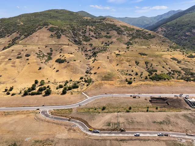 Mountainous terrain, winding paved roads, excavated building sites, natural landscape