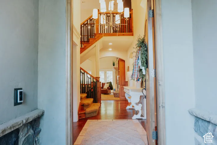 Grand foyer featuring a two-story ceiling, hardwood flooring, and a sweeping staircase with wood banisters